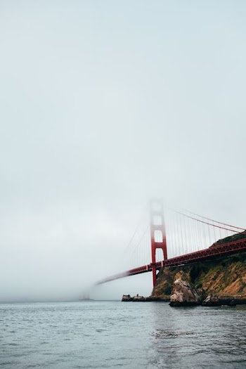 red bridge above mountain under white clouds