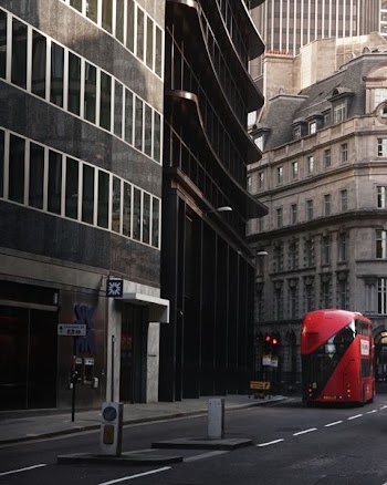 red bus in front of black painted building
