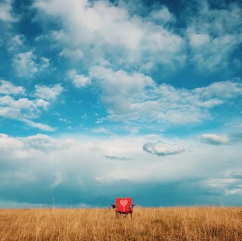 red camping chair on grass field