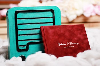 Red Card Leaning on Teal Wooden Box
