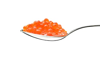 red caviar on a spoon against white background