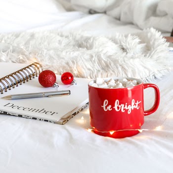 Red Ceramic Mug on White Mat Beside Notebook