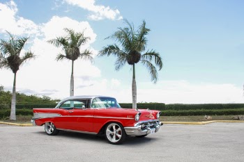 Red Coupe Near Trees Under White Clouds