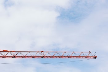 Red Crane Photo Under Cloudy Sky during Daytime