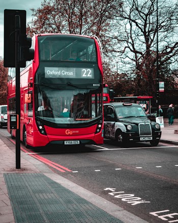 Red Double-Decker Bus Beside Black Taxi Cab On Asphalt Road