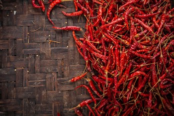 Red dried chilies placed on the space on the weave. Free Photo