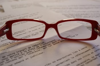 Red Framed Eyeglass on Top of Paper