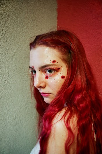 Red-haired Female Beside White and Red Wall