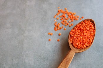 Red lentils in a wooden spoon 
