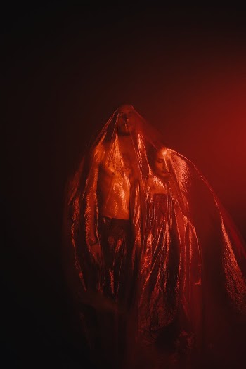 Red Light on Man and Woman Standing under Plastic Sheet