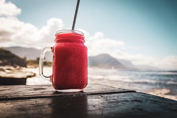 Red Liquid Filled Glass Jar on Wooden Plank