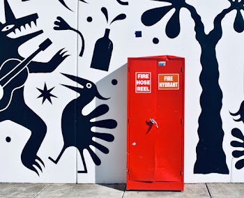 Red Metal Cabinet in Front of White and Black Wall