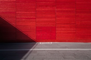 red painted wall and concrete pavement