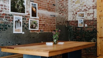 red petaled flower on desk near brown wall