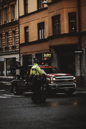 Red Pickup Truck on Roadway Near Brown Building