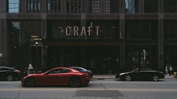 Red Sports Car Passing Craft Building