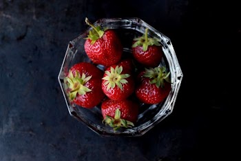 red strawberries in clear glass bowl