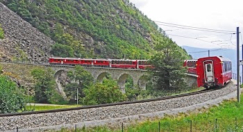 Red Train on Black Steel Train Rail during Day