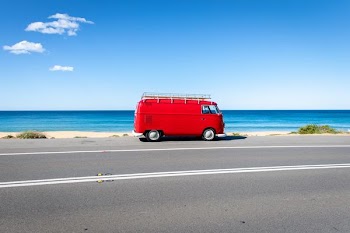 red van on asphalt road near the seashore