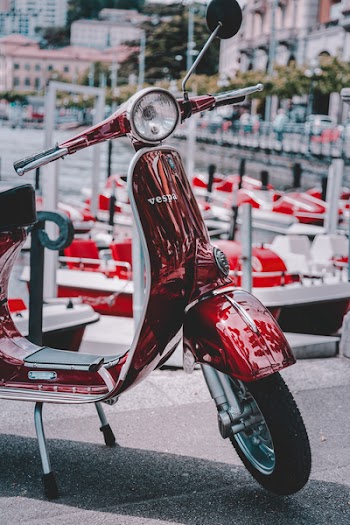 Red Vespa Motor Scooter Parked on Road
