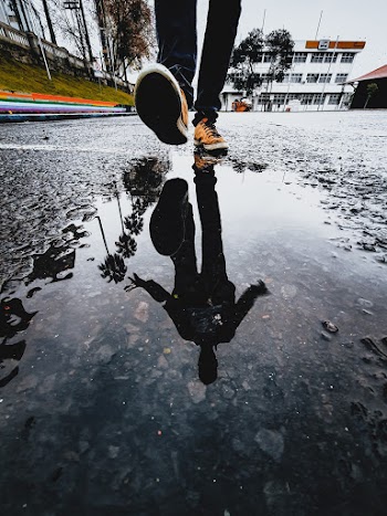 Reflection of a Person Wearing Orange Sneakers