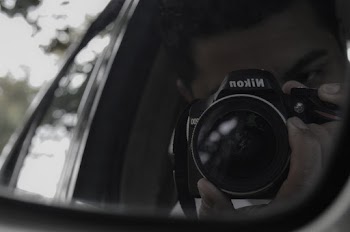 Reflection Of Man Holding Nikon Camera