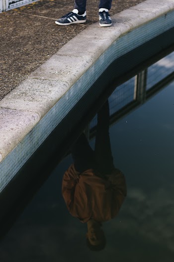 Reflection Photo of Person Standing on Poolside