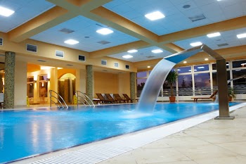 Relaxation Area with swimming pool, artificial waterfalls and wooden chairs