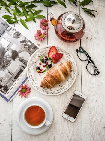 Relaxing with book, tea, croissant and berries 