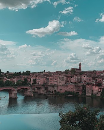 River Beside Concrete Bridge and Buildings
