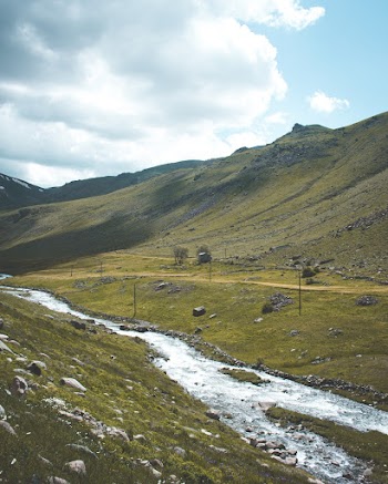 River Flowing Between Green Field