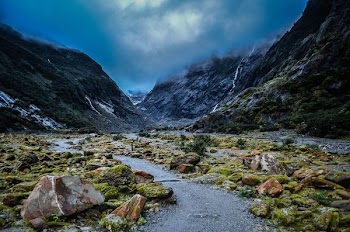 river near mountain under blue sky