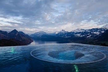 River Surrounded by Mountains Under White Clouds