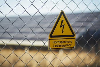 Road Sign Hanging on Chain Link Fence