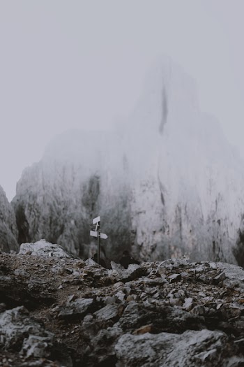 Road Signage Near Snow Covered Mountains
