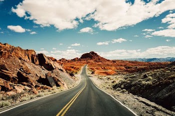road under white and blue sky