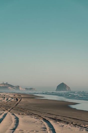 rock formation on water near seashore at daytime