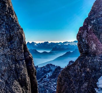 rock mountains with mist in between rock canyon view during daytime