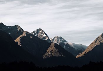 rocky mountain covered with fog taken at daytime