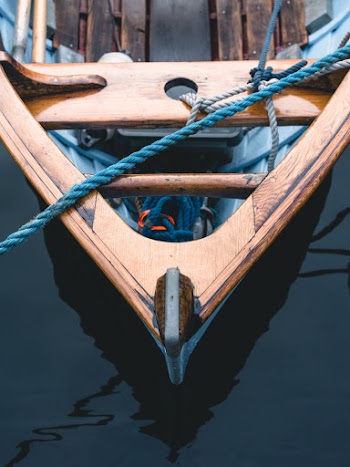 Ropes Tied  on Brown Wooden  Boat on Water
