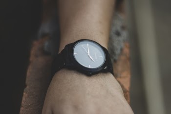 Round Black Analog Watch Displaying 7:15 Time