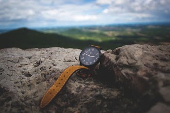 round black analog watch on stone