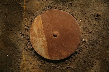 Round Brown Metal Machine Part on Brown Surface