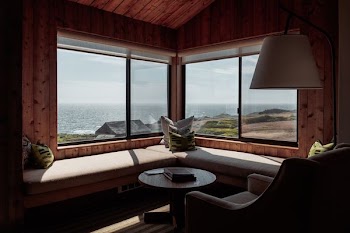 round brown wooden center table near glass window