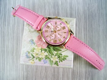 Round Gold-colored Chronograph Watch With Pink Leather Strap on Box