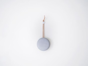 round grey hanging decor on white wall