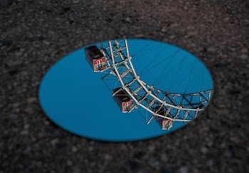 round mirror reflecting ferris wheel