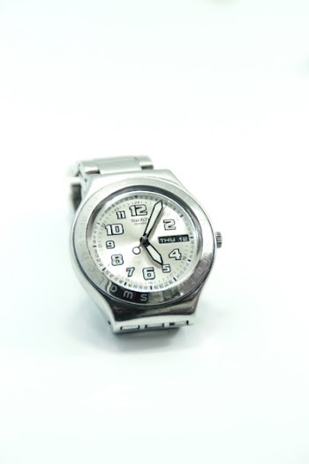 Round Silver-colored Analog Watch Reading at 5:05