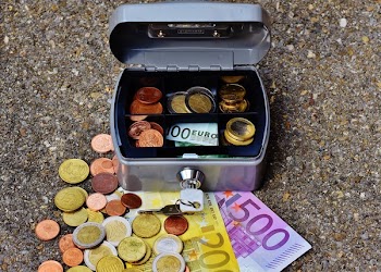 Round Silver-colored and Gold-colored Coin Beside Banknote Near Case