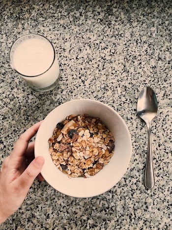 Round White Ceramic Bowl Filled With Oatmeal Beside Glass Of Milk